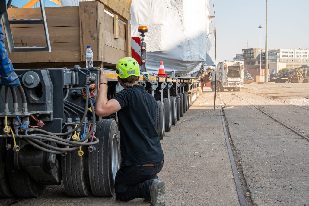 Specialist crew directing oversized transport through city street